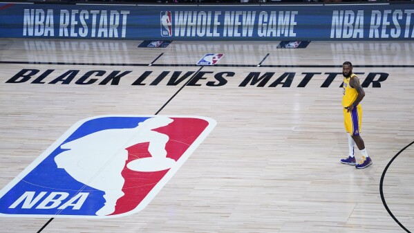 A Black Lives Matter sign is displayed on the court as Los Angeles Lakers' LeBron James prepares to face the Denver Nuggets in an NBA basketball game in Lake Buena Vista, Fla., on Aug. 10, 2020. (AP Photo/Ashley Landis, Pool, File)